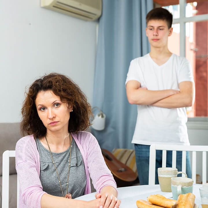 Parent and defiant teen in conflict at home, illustrating how Love and Logic helps parents address both behavior and underlying emotional needs.