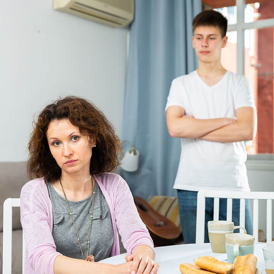 Parent and defiant teen in conflict at home, illustrating how Love and Logic helps parents address both behavior and underlying emotional needs.
