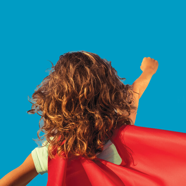 Girl wearing a cape, pretending be a super hero.
