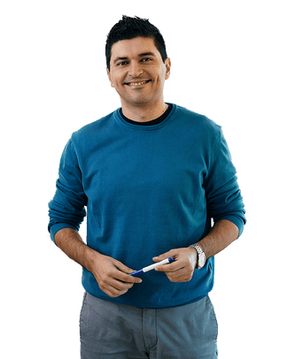Teacher wearing a blue sweater holding a pen