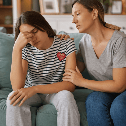 Mother using positive parenting techniques to support a child through a difficult emotional moment