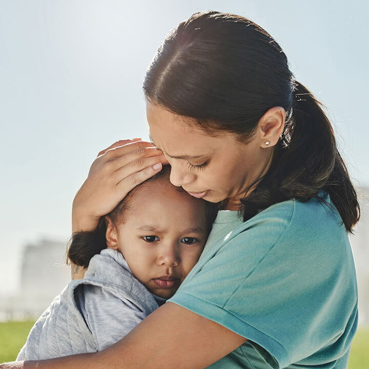 Parent holding a young child calmly, offering comfort and reassurance