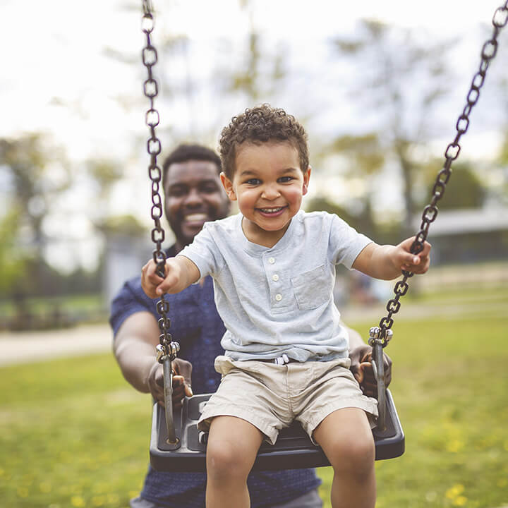 father pushing child on a swing while building a strong parent-child relationship through love and logic parenting