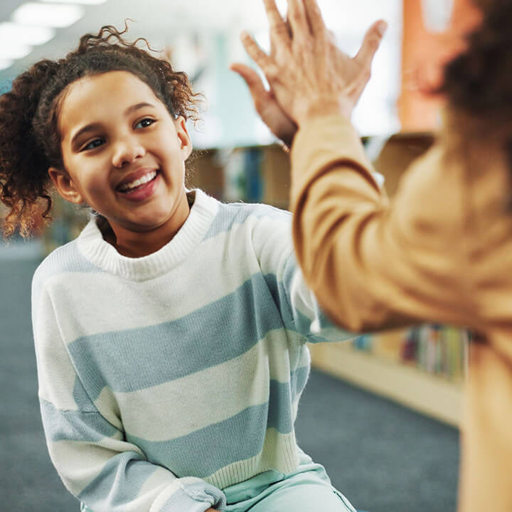 A child celebrating progress with a supportive adult, reflecting encouragement and motivation.