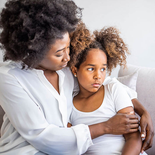 Parent calmly supporting an emotionally upset child to help them regulate and feel safe