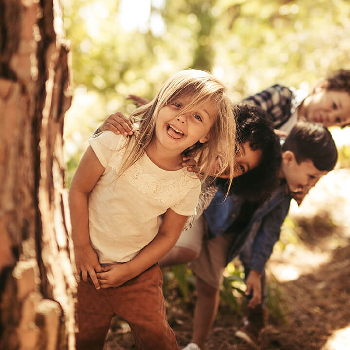 Children playing together outdoors, representing the importance of calm, thoughtful consequences to guide behavior and support positive relationships.