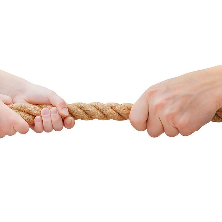 Adult hands pulling opposite ends of a rope, symbolizing power struggles with strong-willed children
